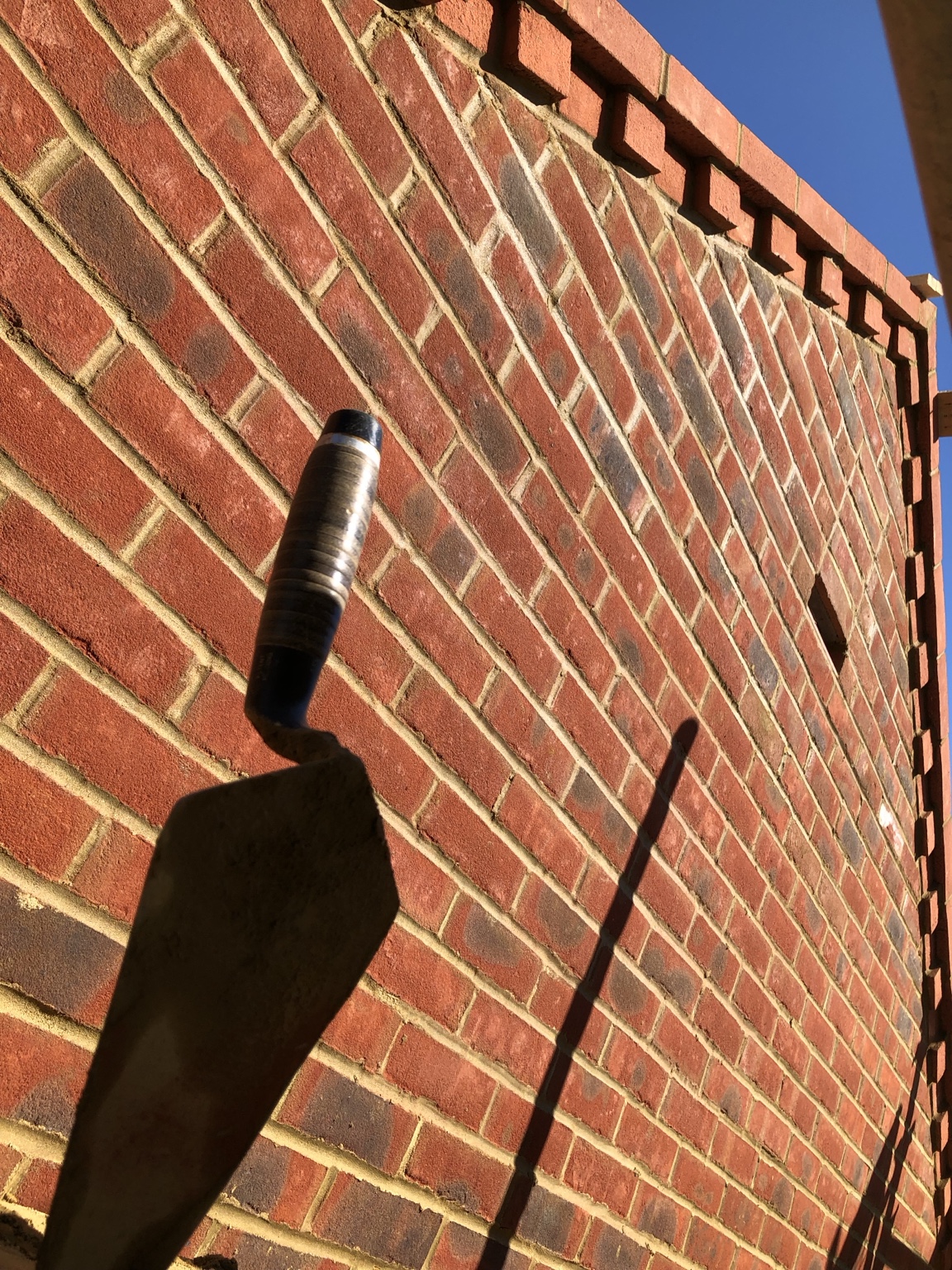 Brick wall being laid with a bricklayer's trowel